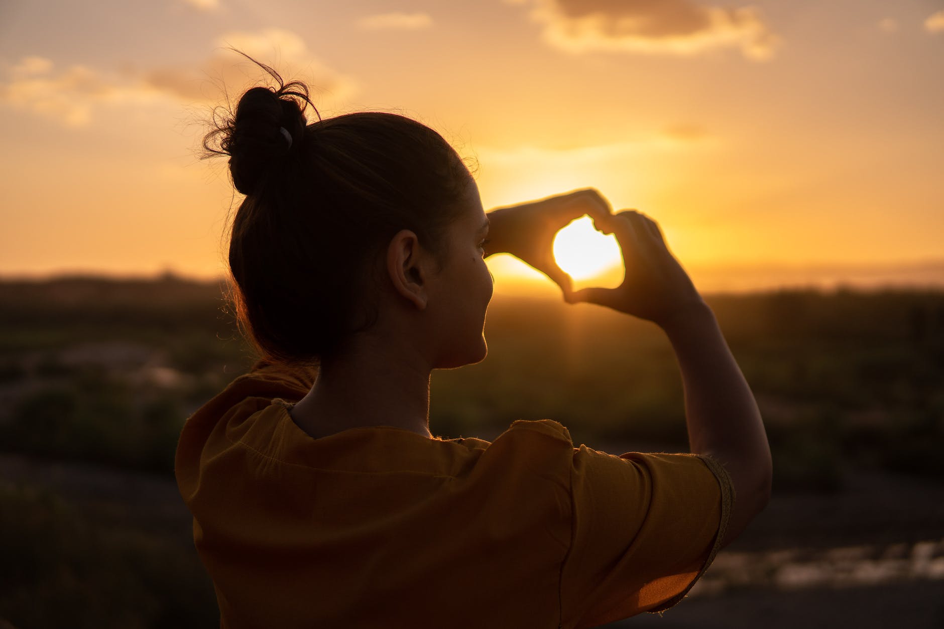 woman doing hand heart sign accompanying article on wellbeing